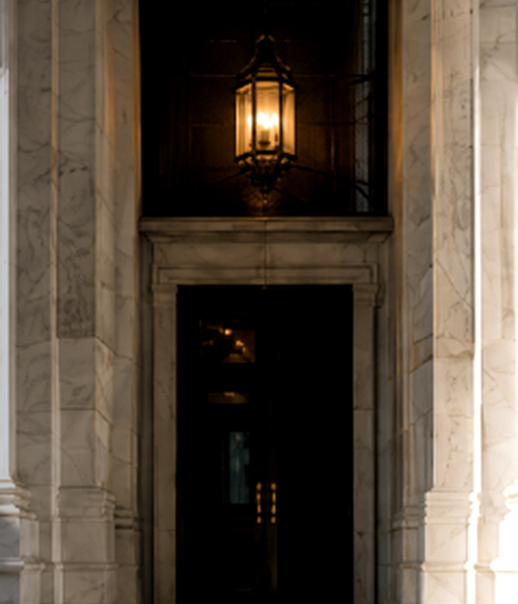Marble private-entry hall illuminated by a brass lantern.